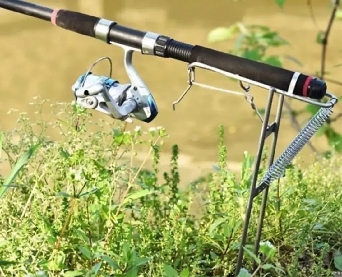 Automatic spring fishing rod holder planted in the ground on a riverbank